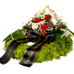 Trauerkranz mit roten Rosen und weißen Lilien