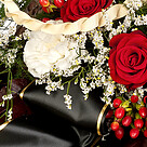 Trauerkranz mit roten Rosen und weißen Lilien
