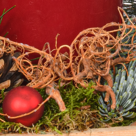 Rotes Adventsgesteck im Holzkasten