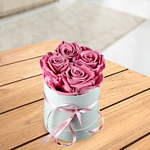 4 old pink roses in a hat box